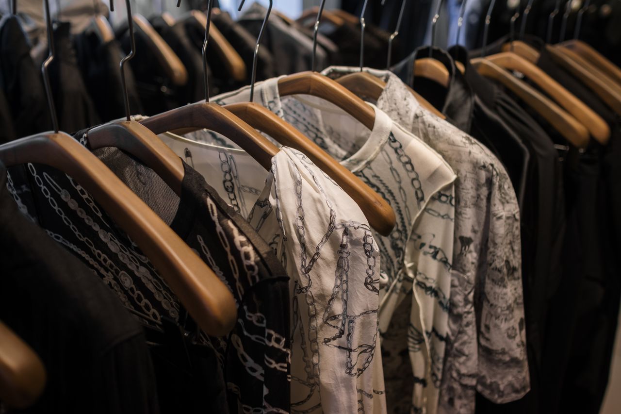 services-04 Elegant clothes on wooden hangers showcasing chic pattern designs in a boutique.